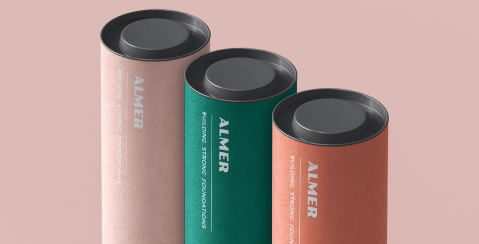 Three rolls of construction materials are branded with the logo for a company called "Almer" and the slogan "Building strong foundations." The rolls are pink, green and orange respectively on a pink background.